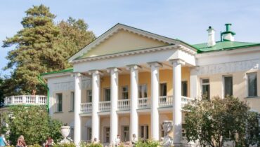 Klassizistisches Herrenhaus mit Säulen, Balkon und Rosengarten