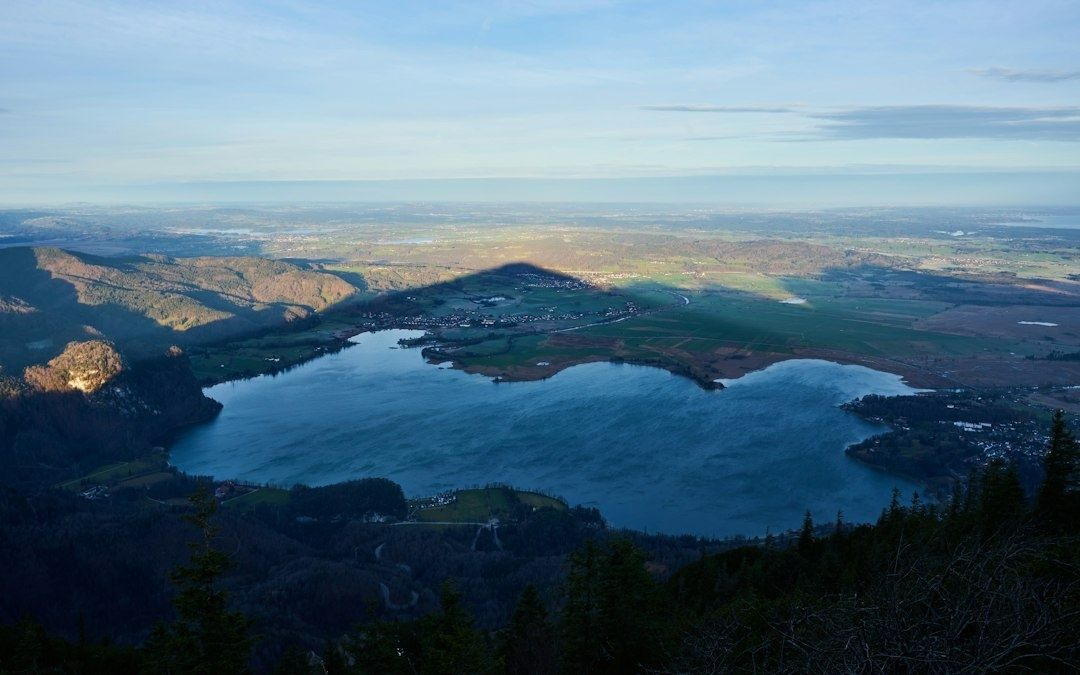 Blick von bewaldeter Höhe auf einen weitläufigen See und das Umland